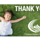 Kid lays in grass with thank you text