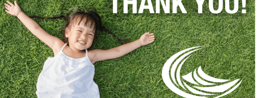 Kid lays in grass with thank you text