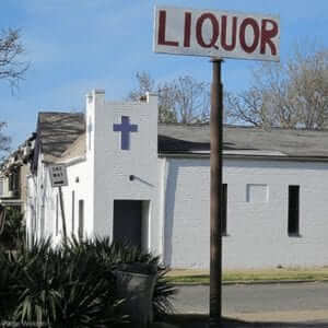 A sign for a liquor store near a church