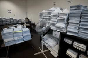 Stacks of claims fill an office room