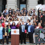 Advocates gather around a podium to celebrate Latino Advocacy Day 2019