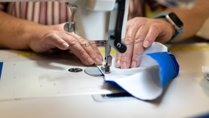 Person sewing a mask on a sewing machine