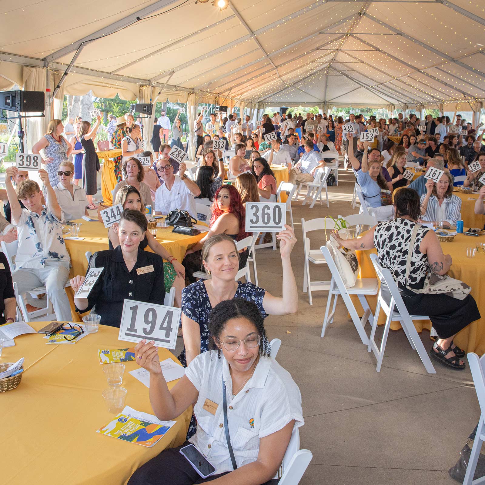 Photos of event attendees under a tent